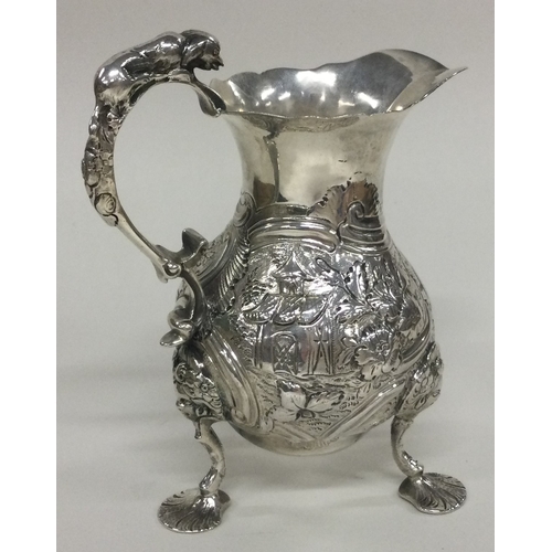 173 - A rare 18th Century silver cream jug with embossed Chinoiserie decoration of scenery, animals and fo... 