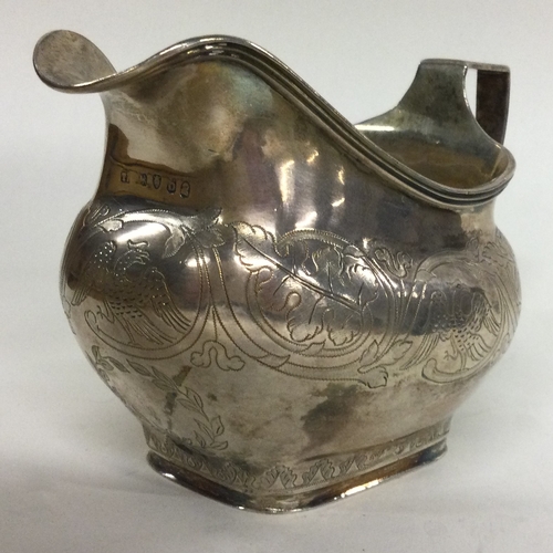 18 - A George III silver jug with chased handle decorated with birds. London 1817. By Thomas Harper. Appr... 