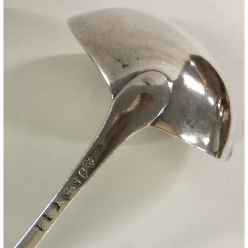 211 - A bottom marked 18th Century crested silver soup ladle with feather edging. Approx. 99 grams. Est. £... 