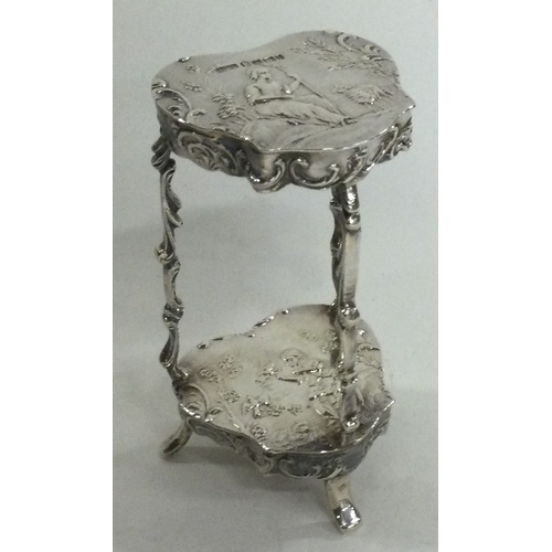 23 - A 19th Century miniature silver table with embossed decoration, bearing import marks. Approx. 41 gra... 