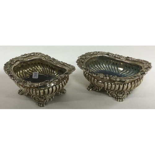 288 - A pair of heavy Georgian silver salt cellars of fluted design on cast feet. London 1822. By George B... 