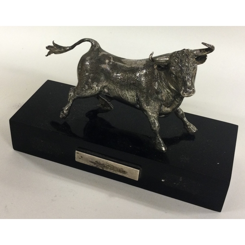 311 - A large silver figure of a bull on plinth. Est. £250 - £300.