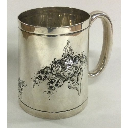 38 - A novelty Victorian silver christening mug chased with flowers. London 1882. By Martin Hall & Co. Ap... 