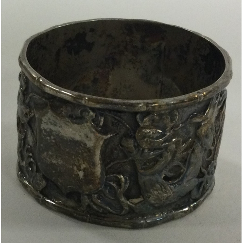 390 - A Chinese silver napkin ring embossed with dragons. Approx. 30 grams. Est. £20 - £30.