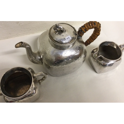 47 - A Chinese export silver three piece tea set of hammered design. Marked to base. Approx. 942 grams. E... 