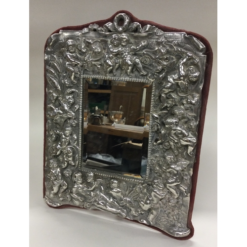 51 - A silver backed mirror embossed with cherubs. Est. £50 - £80.