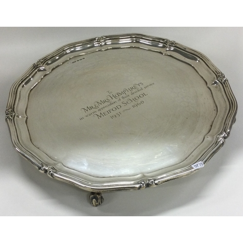 778 - A heavy circular silver salver of scroll form. Approx. 966 grams. Est. £200 - £300.