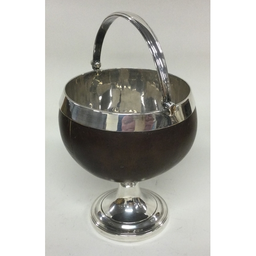 830 - A silver swing handled coconut cup. Approx. 764 grams. Est. £200 - £300.