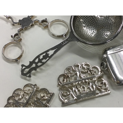 178 - A pair of Georgian silver sugar nips together with a nurses buckle, tea strainer etc. Approx. 142 gr... 