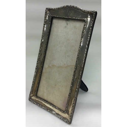 248 - A large silver frame with chased border. Est. £40 - £60.