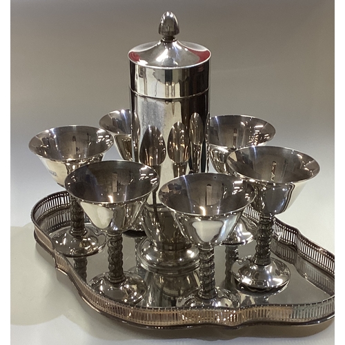 597 - A good silver plated cocktail shaker on tray with six goblets. Est. £50 - £80.