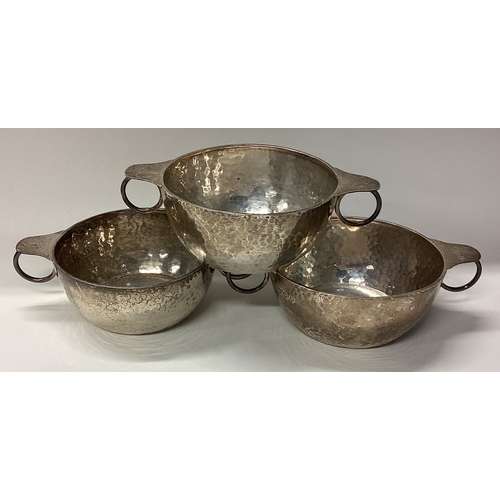 61 - A good set of three tapering silver bowls of textured form. Sheffield.  Approx. 386 grams. Est. £120... 