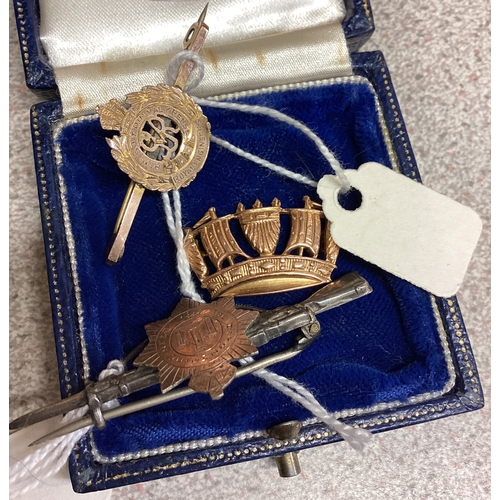 352 - A group of three gold mounted Military brooches. Est. £20 - £30.