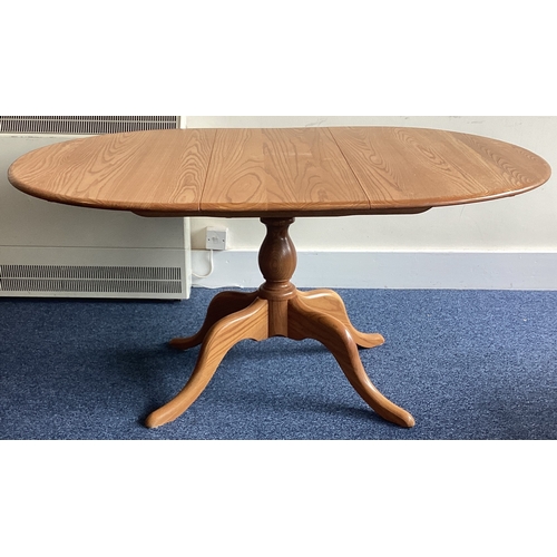 529 - ERCOL: A small oval pedestal dining table. Est. £50 - £80.