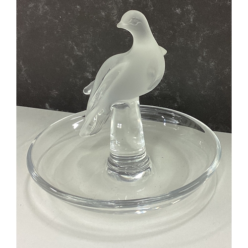 83 - LALIQUE: A small glass pin dish decorated with figure of bird. Est. £30 - £50.