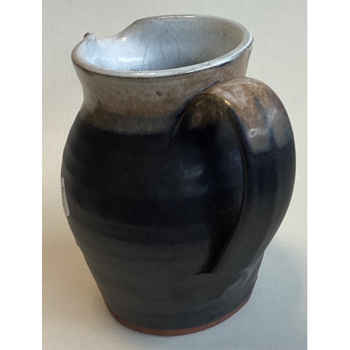 578 - SHANAGARRY: A small terracotta pottery jug in brown matt glaze. Approx. 10 cms high. Marked to base.... 