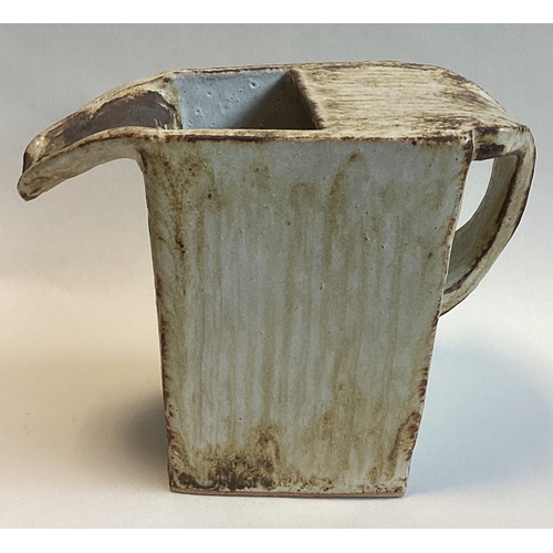 583 - A stylish shaped stoneware jug with fluted sides and formed handle in brown drip glaze. Marked GRA t... 