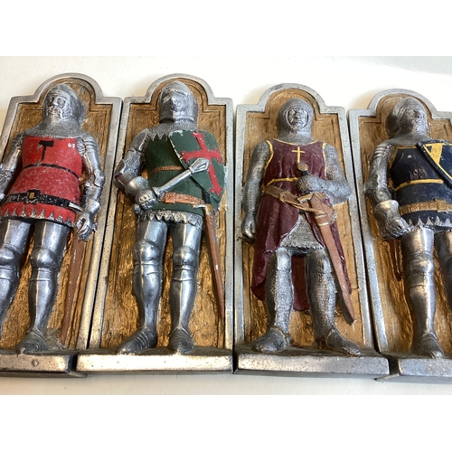 275A - A set of four aluminium wall plaques depicting knights. Est. £30 - £40.