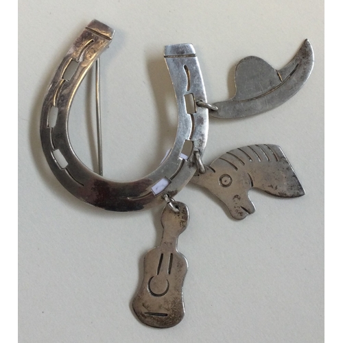 209A - A silver curb link bracelet together with a silver horseshoe brooch with charms. Est. £20 -£30.