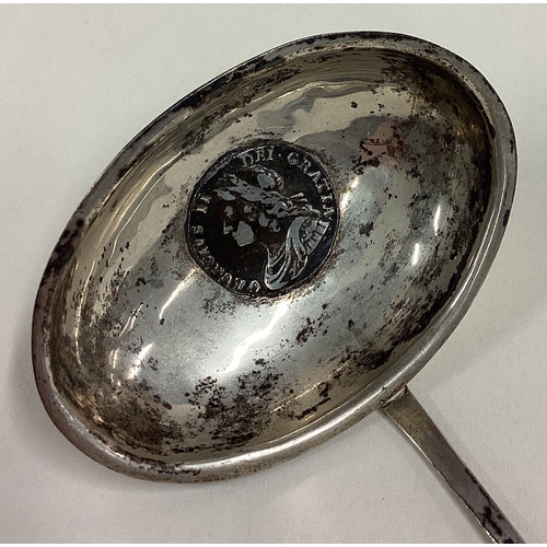 111 - A large Georgian silver toddy ladle with early coin to centre. Approx. 41 grams. Est. £40 - £60.