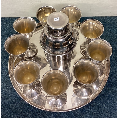 140 - A large silver plated cocktail shaker together with goblets on tray. Est. £30 - £50.