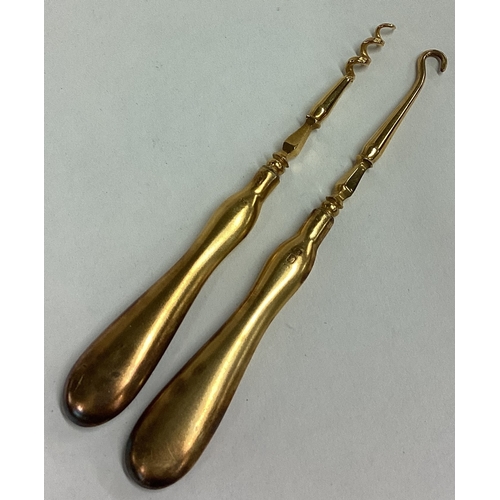 229 - Two silver gilt button hooks. London 1905. Approx. 33 grams. Est. £30 - £40.