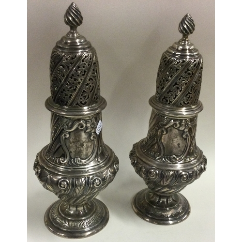 350 - A large pair of Victorian silver sugar casters. London 1888. By Thomas Bradbury & Sons. Approx. 569 ... 