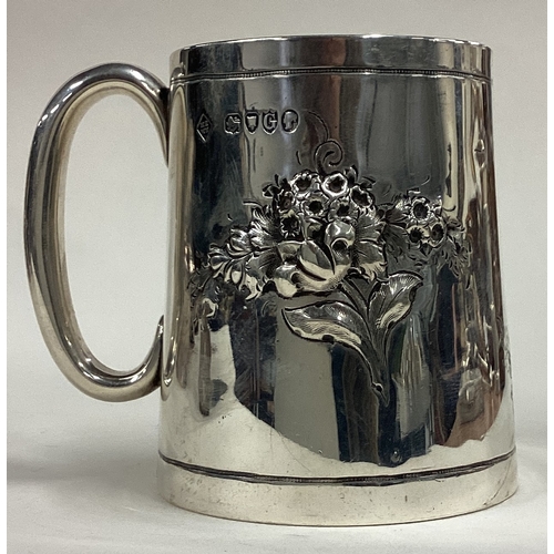 418 - A decorative Victorian silver christening mug chased with floral decoration. London 1882. By Martin ... 