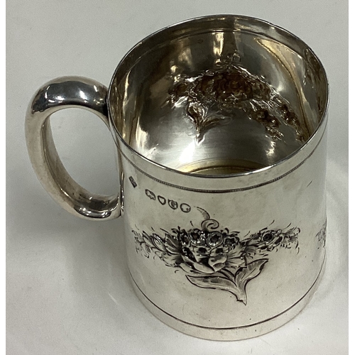 418 - A decorative Victorian silver christening mug chased with floral decoration. London 1882. By Martin ... 