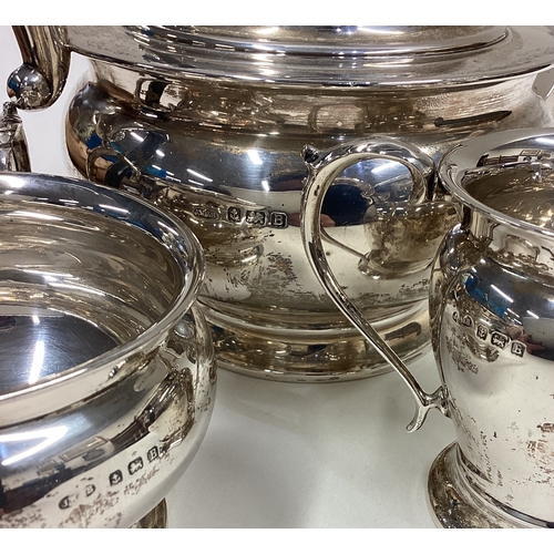 43 - A good circular silver three-piece tea set on pedestal bases. Approx. 340 grams. Est. £200 - £300.