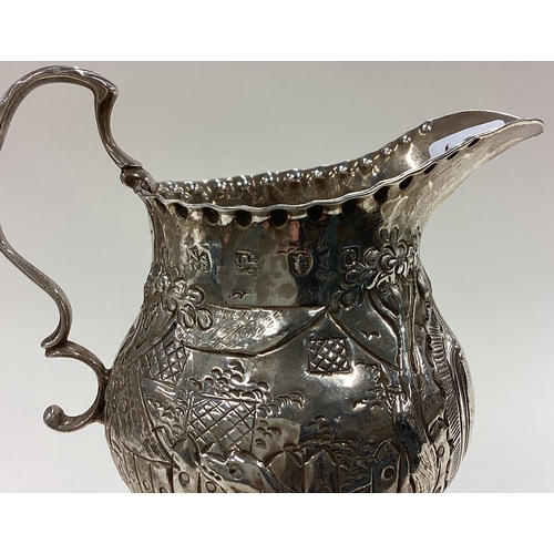 65 - A chased 18th Century Georgian silver cream jug embossed with animals. London 1788. Approx. 88 grams... 