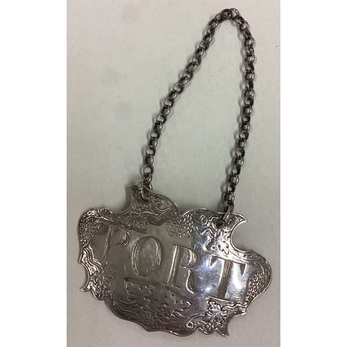 653 - A stylish silver wine label for 'Port' with floral decoration. Approx. 7 grams. Est. £20 - £30.