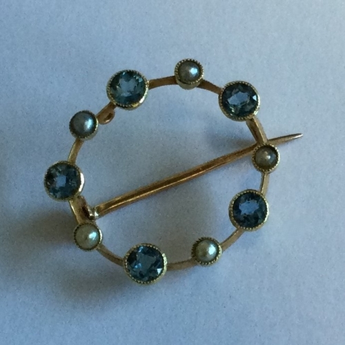 705 - A small circular 15 carat pearl set brooch. Approx. 2 grams. Est. £80 - £120.