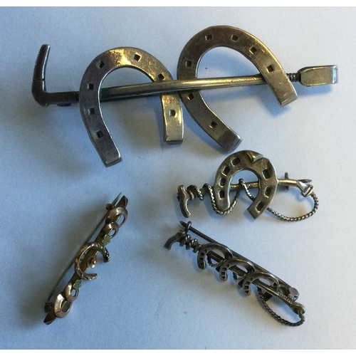 715 - A group of silver mounted brooches to include a horseshoe example. Approx. 26 grams. Est. £20 - £30.