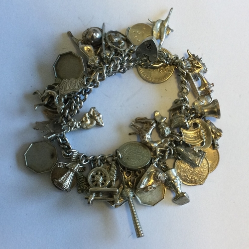 719 - A heavy silver charm bracelet. Approx. 90 grams. Est. £50 - £80.