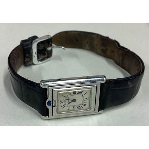 735 - CARTIER: A good lady's stainless steel wristwatch with silvered dial on black leather strap complete... 