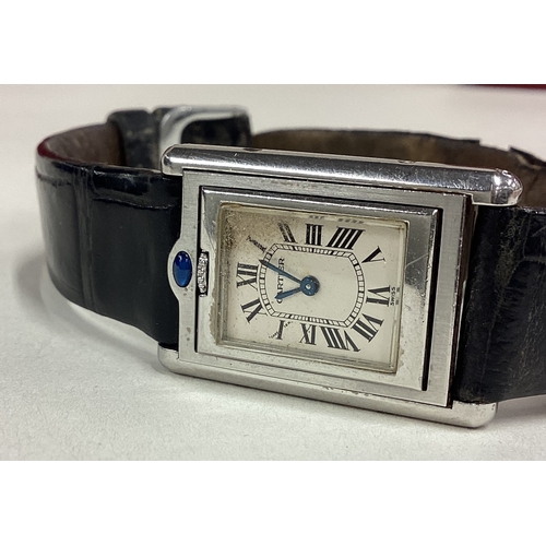 735 - CARTIER: A good lady's stainless steel wristwatch with silvered dial on black leather strap complete... 