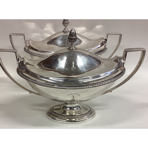 144 - A fine pair of Georgian silver tureens and covers with gadroon rims to reeded handles and crested ar... 