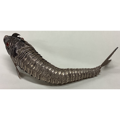 173 - A large Continental silver articulated fish with textured body and stone set eyes. Approx. 134 grams... 