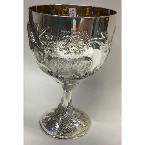 337 - A rare and unusual chased silver goblet embossed with horses and stags to body, and embossed crowned... 