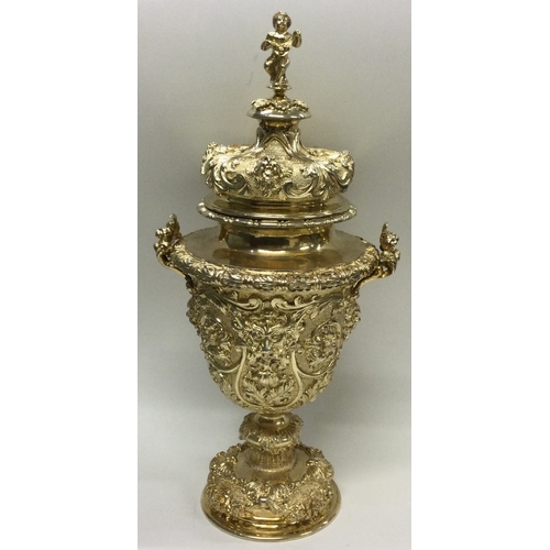 388 - A rare Edwardian silver gilt cup and cover heavily embossed with flowers to cherub finial. London 19... 