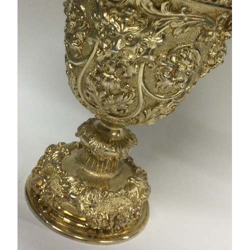 388 - A rare Edwardian silver gilt cup and cover heavily embossed with flowers to cherub finial. London 19... 