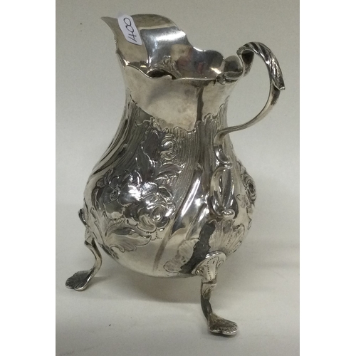 400 - An 18th Century George III silver jug on feet with chased decoration. London 1767. By IS&AN. Approx.... 