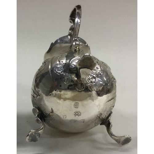 400 - An 18th Century George III silver jug on feet with chased decoration. London 1767. By IS&AN. Approx.... 