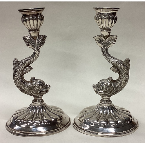 464 - A pair of Sterling silver candlesticks in the form of dolphins. Approx. 520 grams of gross weight. E... 