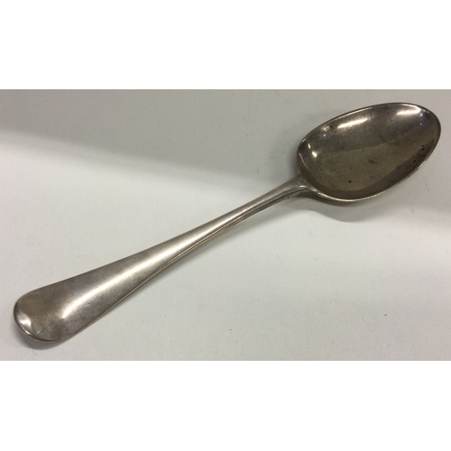 548 - A heavy 18th Century crested silver bottom marked tablespoon. Approx. 73 grams. Est. £60 - £80.