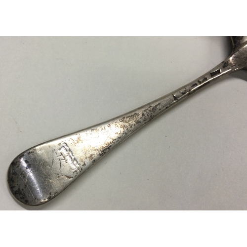 548 - A heavy 18th Century crested silver bottom marked tablespoon. Approx. 73 grams. Est. £60 - £80.