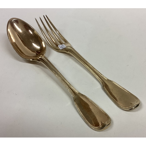 564 - A salmon crested 18th Century silver gilt spoon and fork. Approx. 131 grams. Est. £150 - £200.