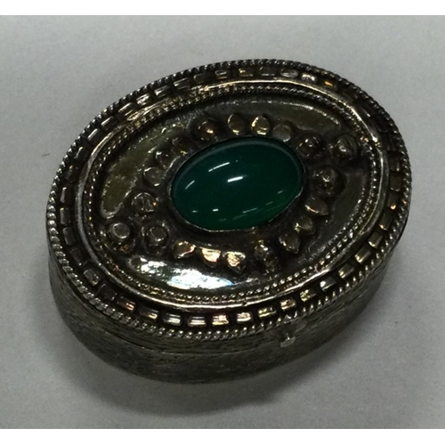 88 - A silver pill box with hinged cover and green stone to centre. Marked to base. Approx. 27 grams. Est... 