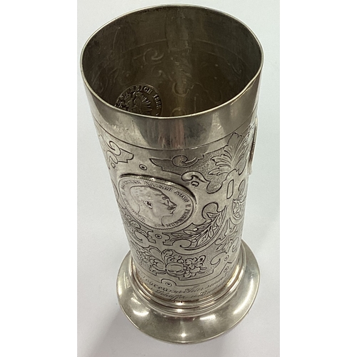 111 - A German silver beaker with coin inserts. Approx. 200 grams. Est. £300 - £400.